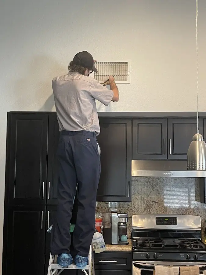Technician inspecting an air vent during HVAC service in Ridgefield Park village